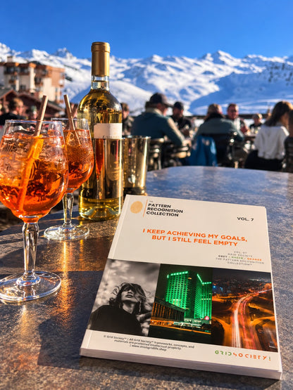 A book titled 'I KEEP ACHIEVING MY GOALS, BUT I STILL FEEL EMPTY' from the Pattern Breaker Collection Vol. 7 is displayed on a bar table in front of a mountain restaurant background.